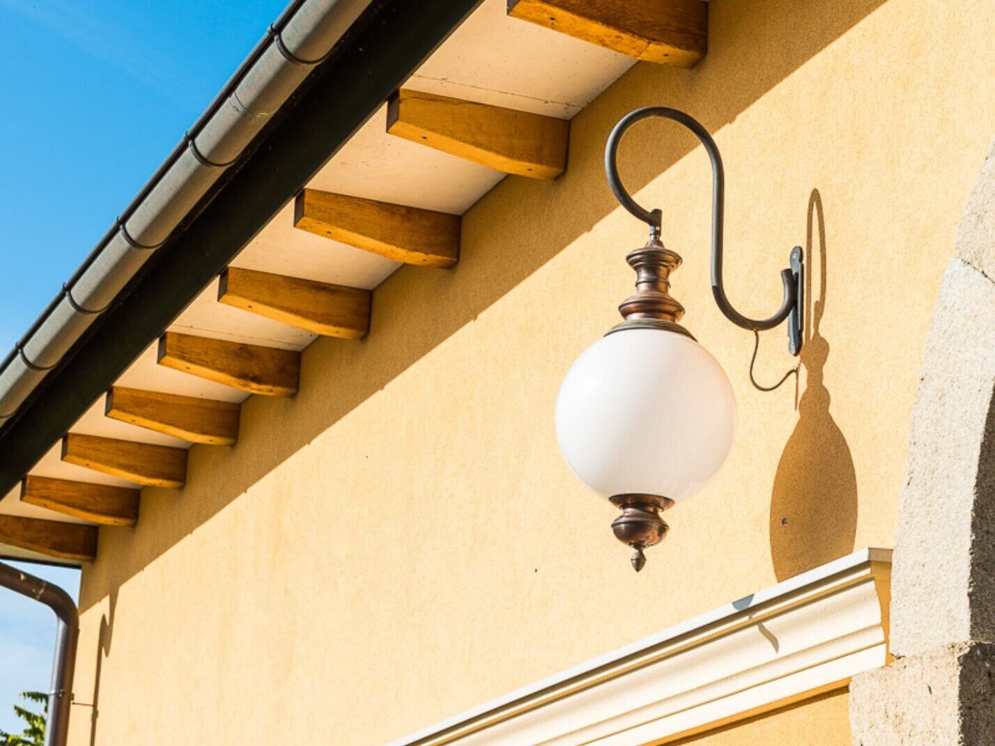 Kugelwandleuchte Genau aus braun patiniertem Kupfer und mit geschwungenem anthrazitgrauem Wandausleger Kugelwandleuchte Genau aus braun patiniertem Kupfer und mit geschwungenem anthrazitgrauem Wandausleger