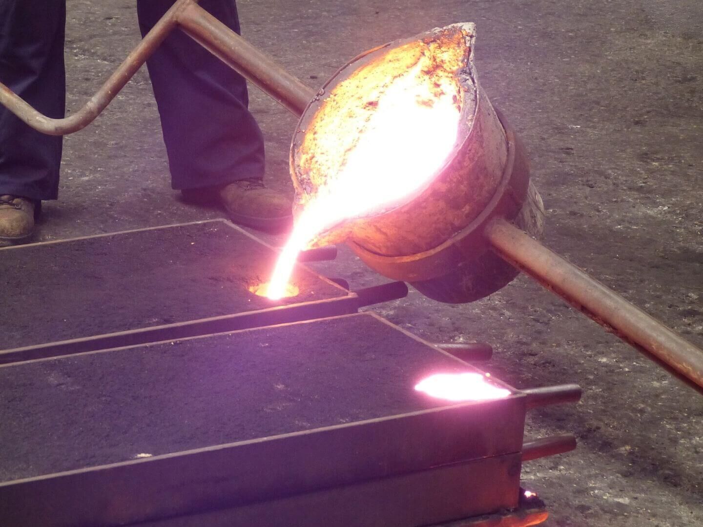 Reproduktion historischer Geländer: flüssiges Metall in Sandform einfüllen Reproduktion historischer Geländer: flüssiges Metall in Sandform einfüllen