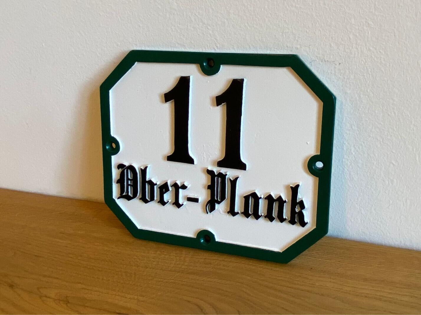 klassische Aluminiumguss Hausnummerntafel "Provinz" mit Frakturschrift und gruenem Rand klassische Aluminiumguss Hausnummerntafel "Provinz" mit Frakturschrift und gruenem Rand