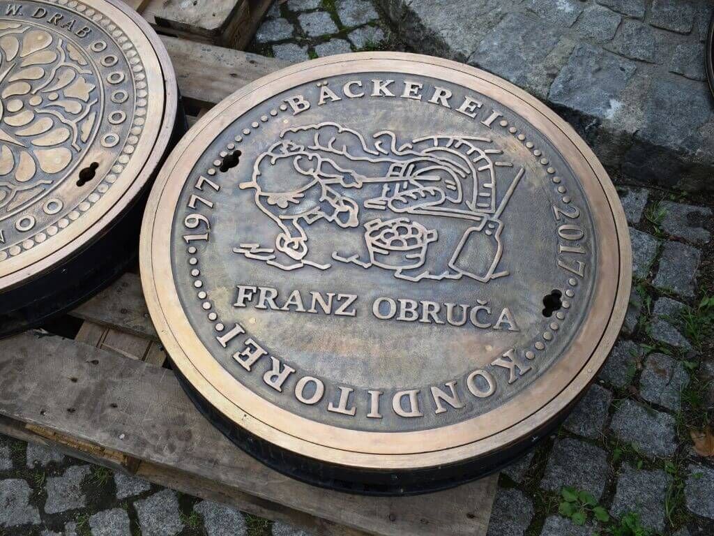 Schachtabdeckung aus Messingguss mit dem Logo der Baeckerei Franz Obruca