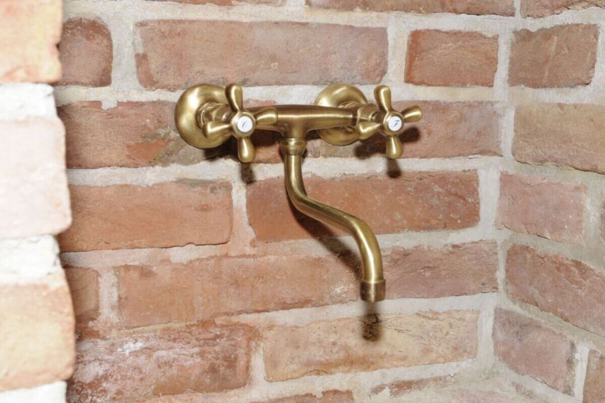 klassische Wandarmatur aus Messing montiert auf Ziegelmauer klassische Wandarmatur aus Messing montiert auf Ziegelmauer