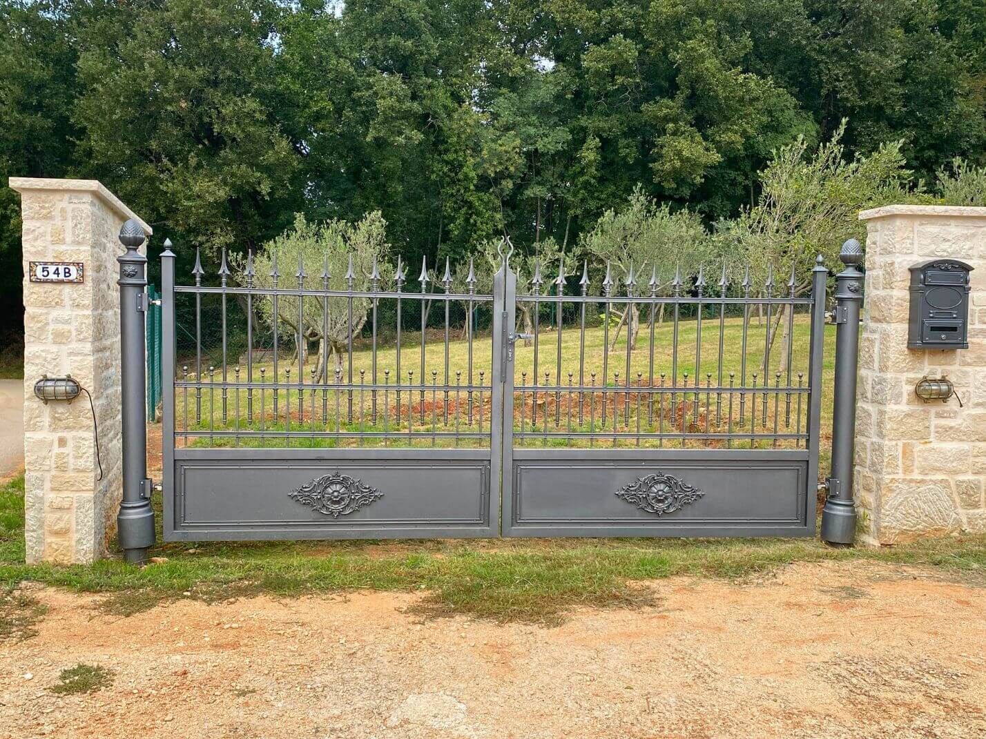 Doppelfluegeliges Einfahrtstor im historischen Stil und nostalgischer Briefkasten aus Gusseisen Doppelfluegeliges Einfahrtstor im historischen Stil und nostalgischer Briefkasten aus Gusseisen