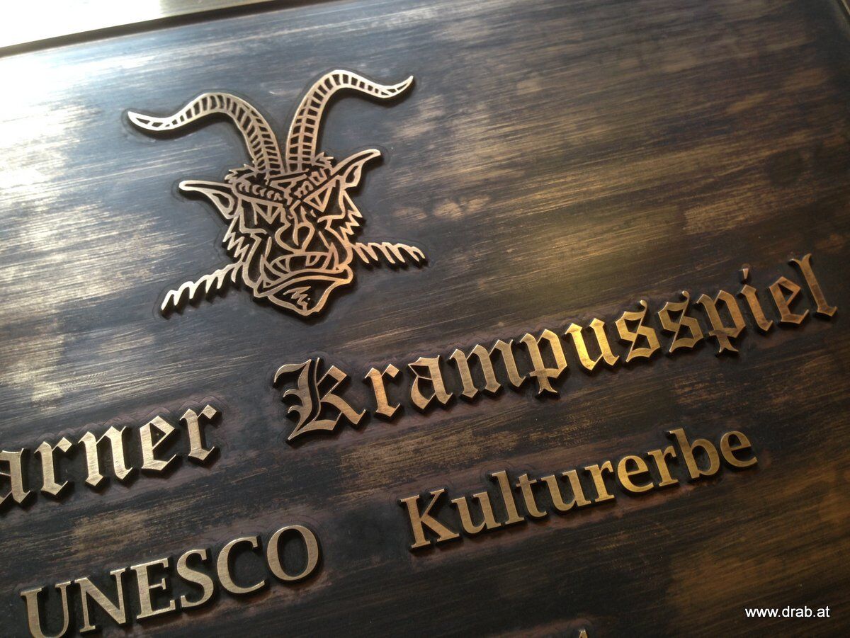 schild_unesco_krampusspiel_messing Hinweistafel aus Aluminium, Messing & Bronzeguss - eigener Text/Muster
