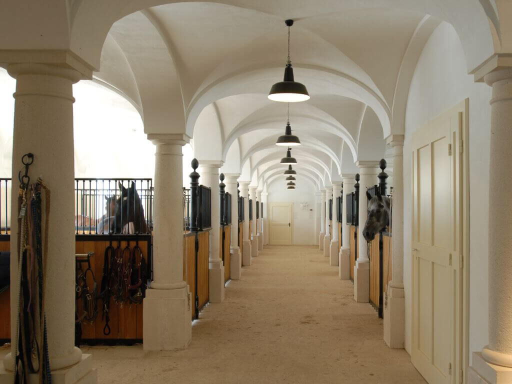 Reitstallbeleuchtung mit schwarzen Haengeleuchten im Industrialstil Reitstallbeleuchtung mit schwarzen Haengeleuchten im Industrialstil