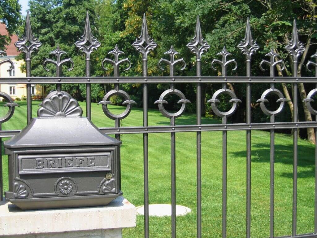 Detailaufnahme des Gusseisenzauns und des Briefkasten Detailaufnahme des Gusseisenzauns und des Briefkasten