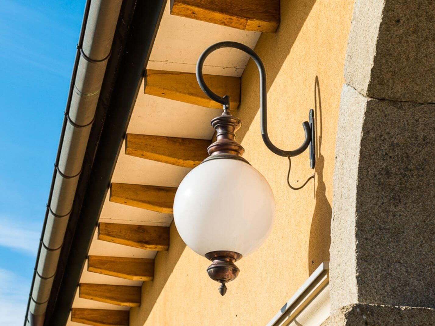 Kugelwandleuchte Genau aus braun patiniertem Kupfer und mit geschwungenem anthrazitgrauem Wandarm Kugelwandleuchte Genau aus braun patiniertem Kupfer und mit geschwungenem anthrazitgrauem Wandarm