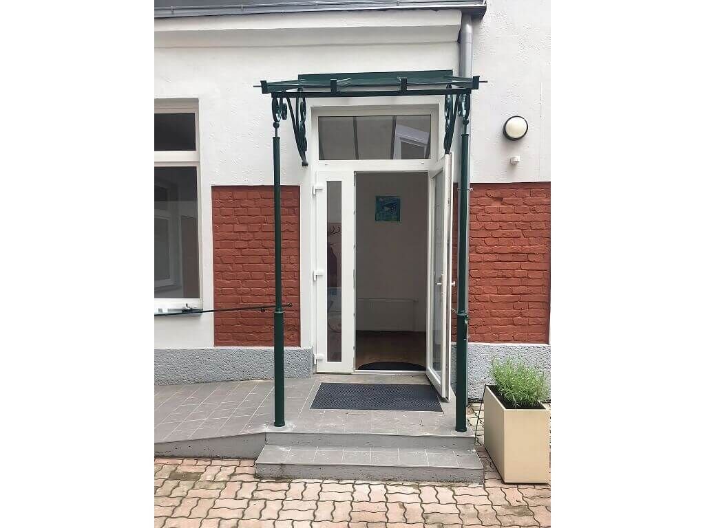 Frontansicht des Vordachs aus Schmiedeeisen mit Glasueberdachung Frontansicht des Vordachs aus Schmiedeeisen mit Glasueberdachung